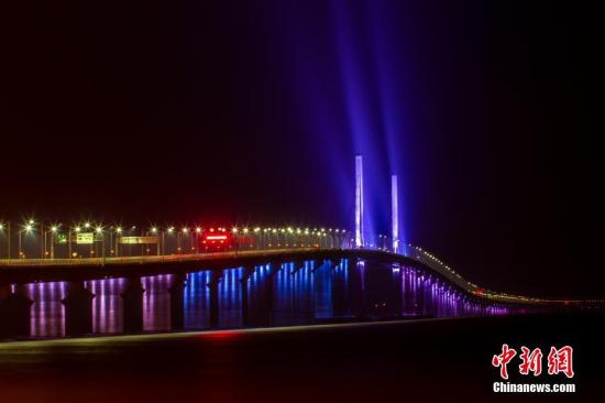 12月31日，港珠澳大橋全線亮燈，標志著全線供電照明系統施工圓滿完成，意味著港珠澳大橋主體工程已經具備通車條件。亮燈儀式上，大橋東人工島四周燃放起壯麗的煙花。圖為港珠澳大橋嵌有“中國結”的青州橋亮起了燈光。鄧媛雯 攝