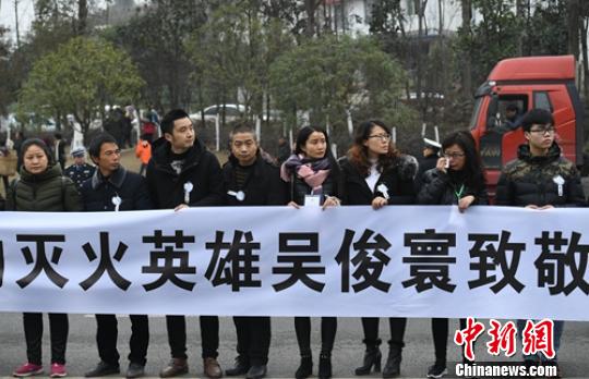 民眾拉起橫幅送消防英雄魂歸故里?！⒅铱?攝