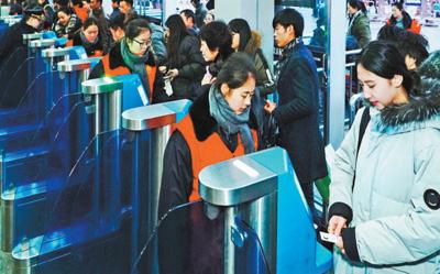 2月1日，旅客正在北京西站通過自助驗票設備“刷臉”進站。該站今年增加了18臺人臉識別設備，方便旅客快速進站。本報記者 賀 勇攝