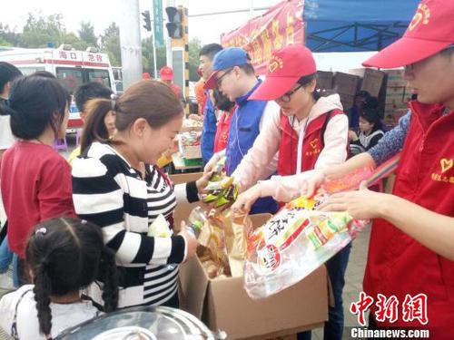 2月21日，海口新海港附近，志愿者為旅客發(fā)放食物?！∫Ｃ?攝