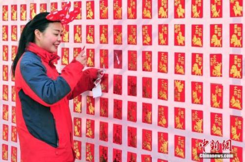 資料圖：2018年2月16日，大年初一，游客來(lái)到天津方特歡樂(lè)世界紅包墻前搶包紅。<a target='_blank' href='http://www.chinanews.com/'>中新社</a>記者 佟郁 攝