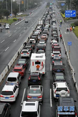 2月23日，車輛在海口市丘海大道排隊等待入港登船。