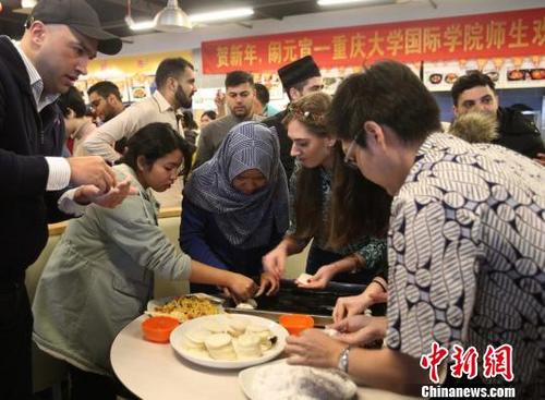 中國僑網圖為重慶大學留學生包餃子和湯圓共慶元宵節?！＄娦馈z