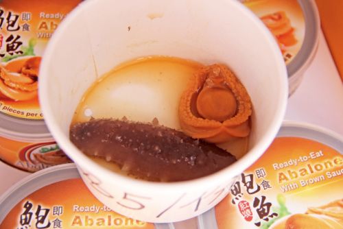 5美元一份的鮑魚海參餐，許多游人買來邊走邊吃。（美國《世界日報》／記者李晗 攝影）