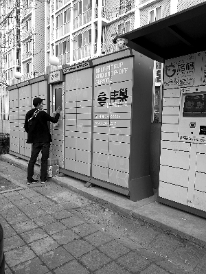 快遞員掃碼將快遞包裹逐一放入柜子中。圖片來源：北京晨報