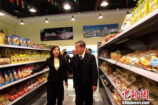 中國商業(yè)聯(lián)合會會長姜明(前右)參觀天津安全食品體驗中心。　張道正 攝