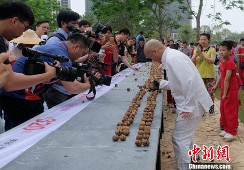 黎偉軍手劈核桃現(xiàn)場吸引不少人圍觀。　程景偉 攝