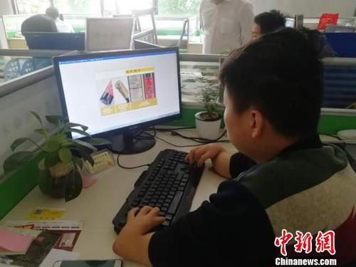 4月28日，在江西省寧都縣電商園103室，美編在設(shè)計圖片。　蘇路程 攝