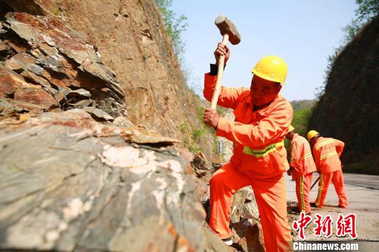 楊衛(wèi)東帶領(lǐng)工友們正在清理落石?！⒗^東 攝