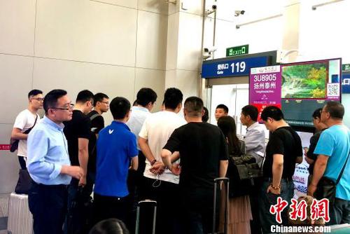 圖為大批乘客向成都雙流機場工作人員了解延誤原因。　黃心玥 攝