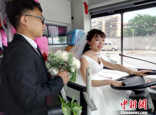 李金可駕駛公交車(chē)行駛，丈夫手捧鮮花守護(hù)在側(cè)。　朱幸 攝