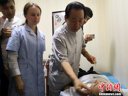 圖為甘肅岐黃國(guó)醫(yī)館負(fù)責(zé)人何天有現(xiàn)場(chǎng)向國(guó)外中醫(yī)愛(ài)好者教學(xué)“針灸”。　魏建軍 攝