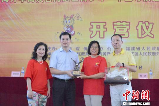 中國僑網(wǎng)7月9日，2018年海外華裔及臺灣地區(qū)青少年“中國尋根之旅”夏令營——福建洛江營開營式上，主辦方互贈紀念品。　孫虹　攝