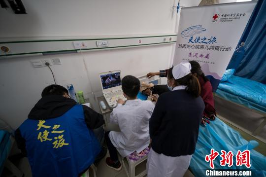 圖為醫(yī)療專家通過心臟彩超篩查先心病患兒。　何蓬磊 攝
