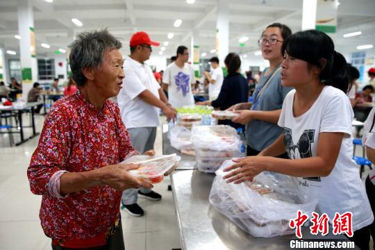 8月24日，志愿者在濰坊壽光市營里鎮第二初級中學安置點為災民發放救援物資。　梁犇 攝