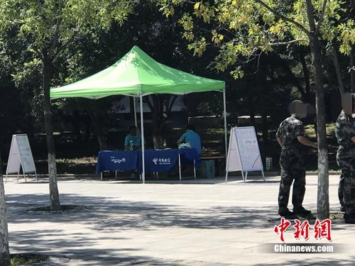 中國電信在某高校內(nèi)擺攤出售手機(jī)卡，旁邊就是正在軍訓(xùn)的學(xué)生。<a target='_blank' href='http://www.chinanews.com/' >中新網(wǎng)</a> 吳濤 攝