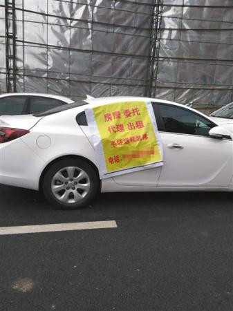 托管中介搶房大戰，搶房廣告甚至貼在車上。新京報記者 黃鑫宇 攝