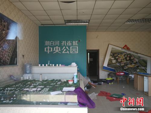 從一家已經關門的售樓處門外望進去，地上散落著廢紙、條幅，沙盤上放著落灰的殺蟲劑。<a target='_blank' href='http://www.chinanews.com/' >中新網</a>記者 邱宇 攝