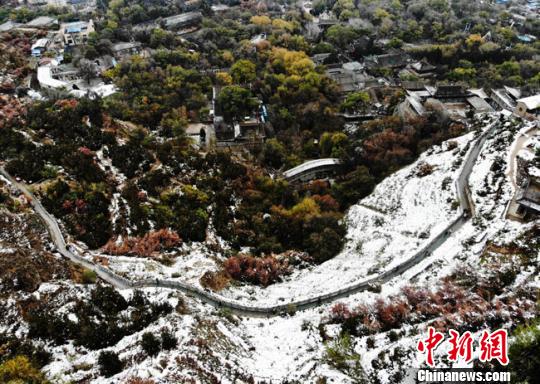 11月4日早晨，航拍視角中的蘭州城區(qū)一角，繽紛秋色中點(diǎn)綴著點(diǎn)點(diǎn)白雪。　楊艷敏 攝