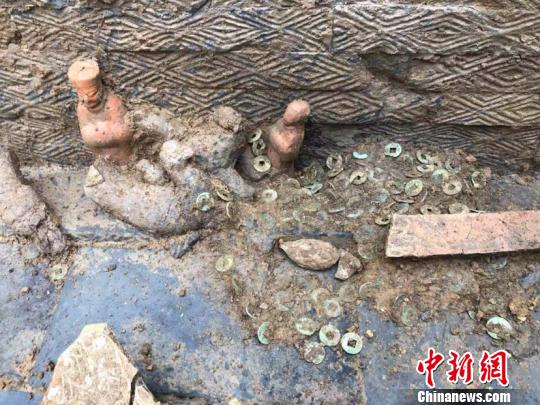 圖為墓葬出土的陶俑和銅錢。(鐘欣攝)