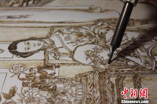 圖為正在創作中的烙畫作品?！⌒煅?攝