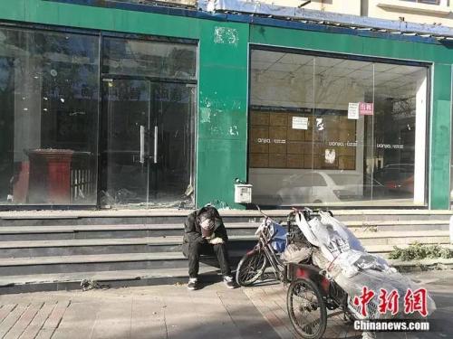 2018年10月，燕郊“售樓一條街”，已經關門的鏈家門店前停著一輛裝貨的三輪車，車的主人坐在地上，把頭深深地埋進臂彎。<a target='_blank' href='http://www.chinanews.com/' >中新網</a>記者 邱宇 攝