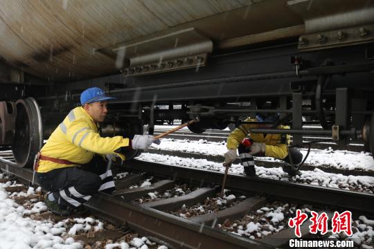 南京東車輛段貨車檢車員風雪里按標準作業，保障運輸安全。　劉寅 攝