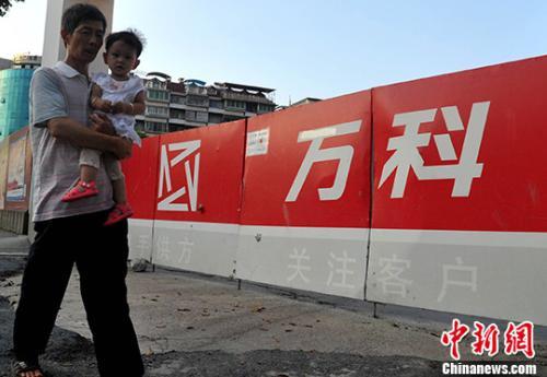 資料圖：民眾從萬科某樓盤工地旁經(jīng)過。<a target='_blank' href='http://www.chinanews.com/'>中新社</a>記者 張斌 攝