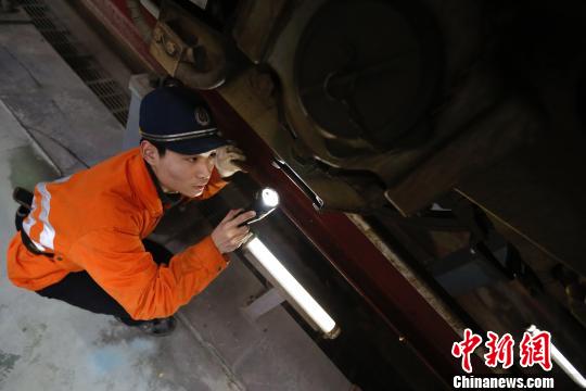 動車機械師正在檢修動車車底部件。　丁波 攝