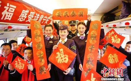 列車員和乘客一起展示春聯(lián)和福字。　張婭子　攝