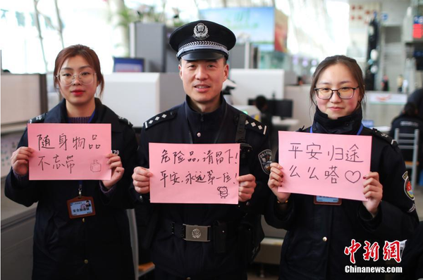 2月1日，隨著春節(jié)臨近，南京鐵路公安處南京站派出所的民警在紙上寫下“平安春運(yùn)，有我們護(hù)航”、“天下無賊是我們最大的心愿”、“平安歸途么么噠”等話語，用別樣的方式給旅客們送上溫馨的新年祝福。圖為南京火車站安檢處的民警和工作人員送出溫馨祝福語。中新社記者 泱波 攝