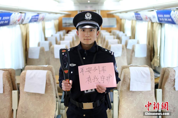 2月1日，隨著春節(jié)臨近，南京鐵路公安處南京站派出所的民警在紙上寫下“平安春運(yùn)，有我們護(hù)航”、“天下無賊是我們最大的心愿”、“平安歸途么么噠”等話語，用別樣的方式給旅客們送上溫馨的新年祝福。圖為執(zhí)行跟車任務(wù)的民警送出溫馨祝福語。中新社記者 泱波 攝