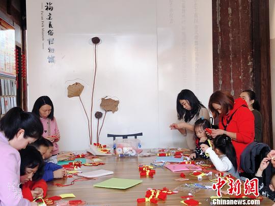 家長(zhǎng)帶著小朋友參與趣味手工體驗(yàn)活動(dòng)。　葉秋云 攝
