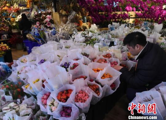 圖為市民在鮮花市場(chǎng)挑選玫瑰花作為情人節(jié)禮物。　周毅 攝