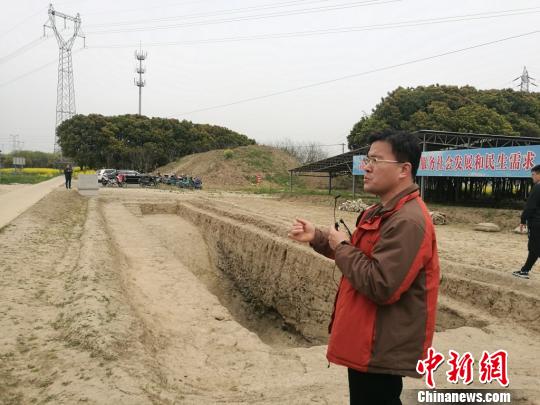 周潤墾在介紹發(fā)掘出的古河道遺址。　鐘升 攝