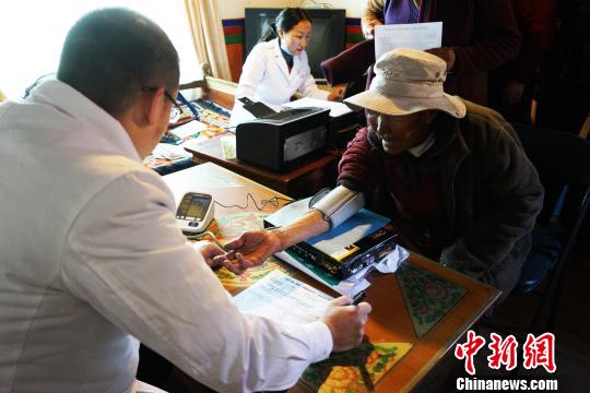 圖為4月10日，來自西藏阜康(國(guó)際)健康體檢中心的彭醫(yī)生(左)為83歲的尼姑旦量血壓。　張偉 攝