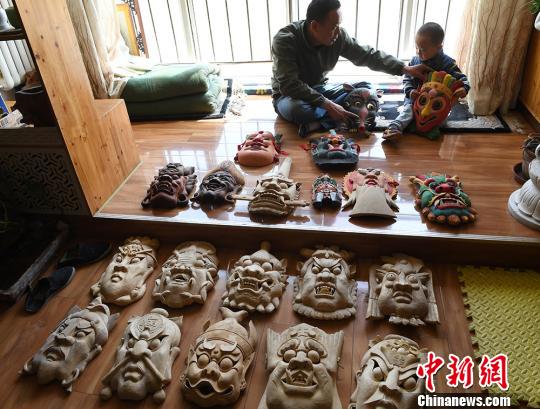 甘肅民間藝人馬正德展示制作的儺面具?！钇G敏 攝