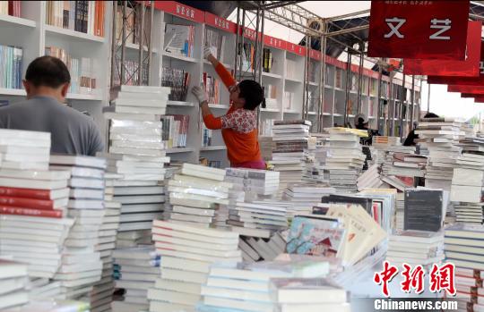 “北京書市”將于4月19日至29日在朝陽公園舉辦。圖為工作人員正在布置展區內各個書架。(完) 張宇 攝