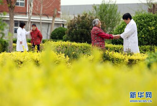 5月5日，在河北省衡水市桃城區一家養老康復醫療中心，護工在陪老人散步。新華社記者 牟宇 攝