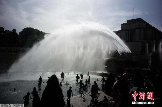當?shù)貢r間2019年6月28日，法國巴黎，法國遭遇連日極端高溫天氣襲擊，眾多巴黎市民和游客聚集在埃菲爾鐵塔前的噴水池泡水降溫。