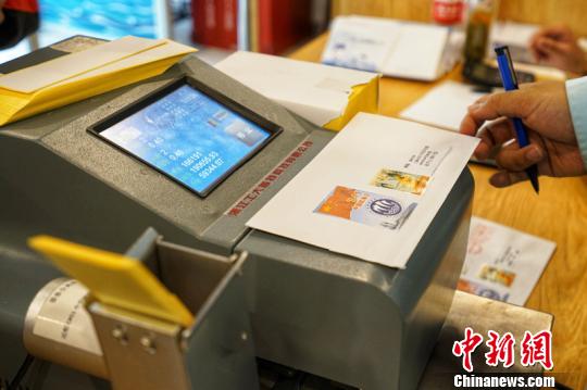 市民等待機(jī)器蓋郵資機(jī)宣傳戳。　董翌 攝