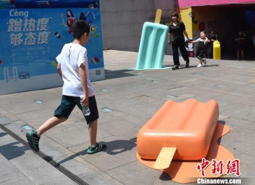 資料圖：圖為重慶一廣場現巨型雪糕模型，吸引小朋友眼球。　周毅 攝