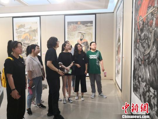 圖為學習繪畫的學生在聽老師講解畫作特色?！钅?攝