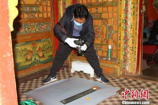 圖為西藏自治區(qū)古籍保護(hù)中心古籍保護(hù)部副主任才洛采集古籍影像信息。　趙朗 攝