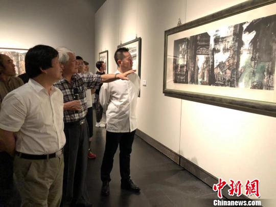 臺灣知名畫家江明賢向來賓講述創作過程。　朱曉穎 攝