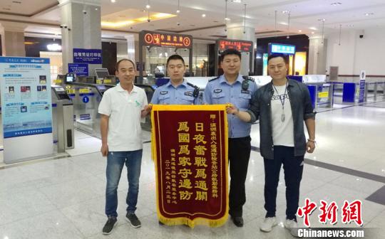贈送執(zhí)勤民警錦旗。　滿洲里邊檢站供圖 攝