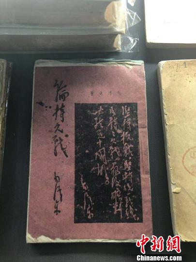 一本用白、紅、藍(lán)等五種顏色紙張印刷而成的《論持久戰(zhàn)》。　李庭耀 攝