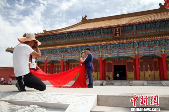 圖為新人在蘭州新區(qū)網(wǎng)紅打卡地“長城影視城”拍結(jié)婚照。　丁凱 攝