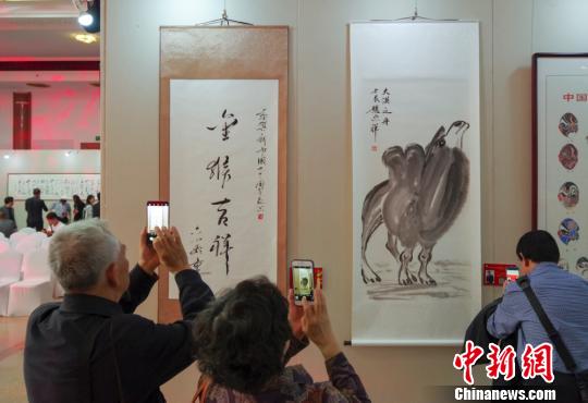 9日，觀眾在“慶祝中華人民共和國成立70周年——影視藝術家優秀書畫作品展”上參觀六小齡童的書法作品《金猴吉祥》和趙忠祥的畫作《大漠之舟》。　<a target='_blank' href='http://www.chinanews.com/'>中新社</a>記者 賈天勇 攝