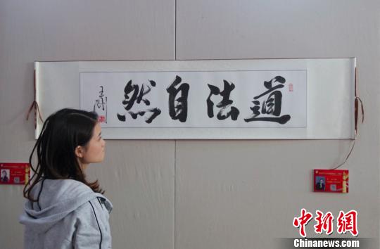 9日，觀眾在“慶祝中華人民共和國成立70周年——影視藝術家優秀書畫作品展”上參觀王剛的書法作品《道法自然》。　<a target='_blank' href='http://www.chinanews.com/'>中新社</a>記者 賈天勇 攝
